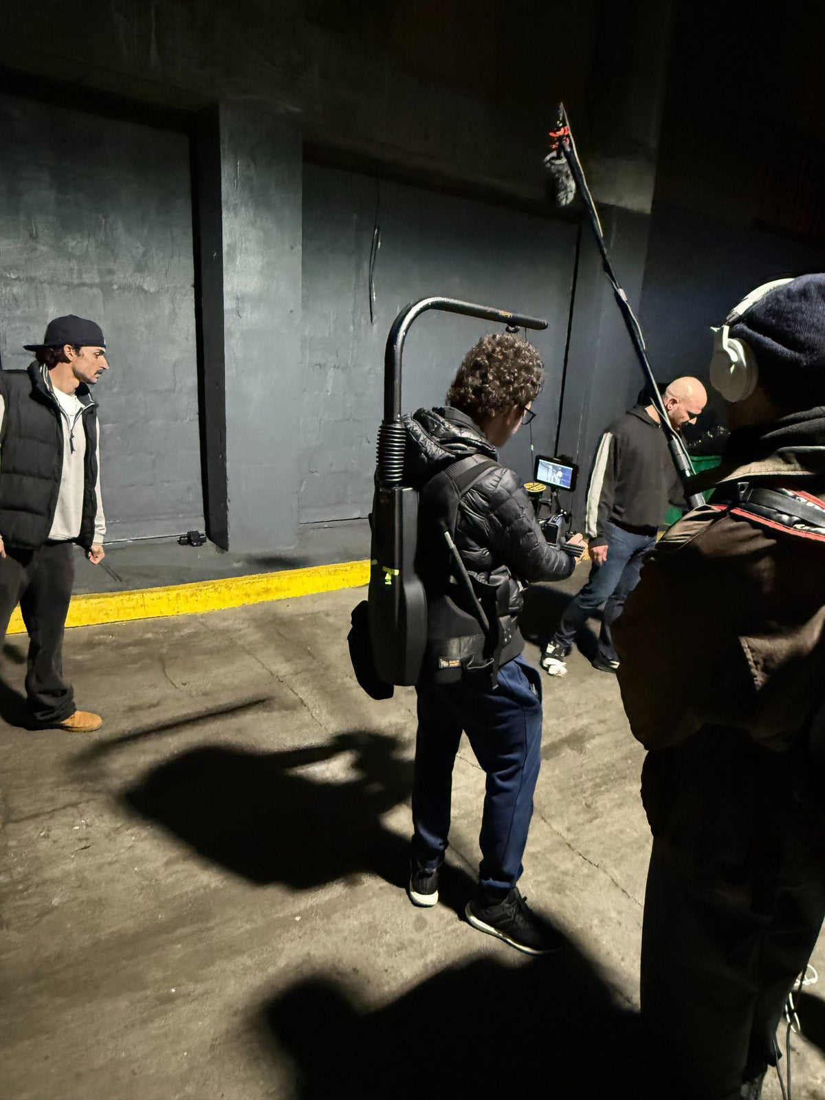 Film crew working with a camera and boom microphone.